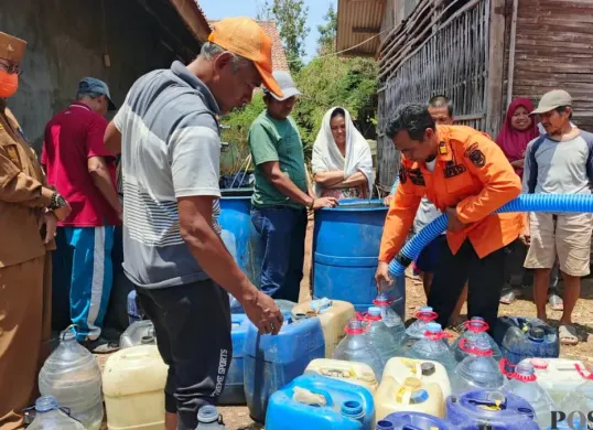 Petugas BPBD Kabupaten Purwakarta menyalurkan air bersih untuk kebutuhan MCK warga terdampak kekeringan. (Sumber: Poskota/Dadan Sukmana)