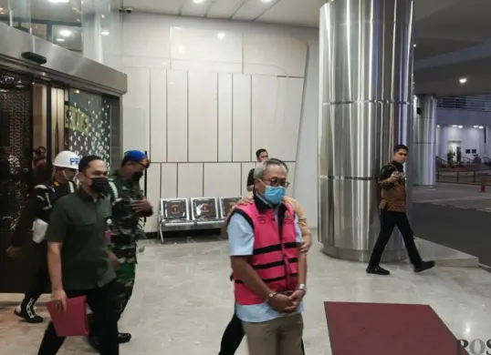 Salah satu tersangka kasus dugaan korupsi tata kelola dan ekspor komoditas nikel dibawa ke mobil tahanan di Kejaksaan Agung (Kejagung), Jakarta Selatan, Jumat, 25 September 2026. (Sumber: Poskota/Ali Mansur)