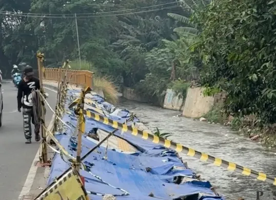 Potret trotoar Taman Secawan Depok yang amblas dan belum diperbaiki. (Sumber: Poskota/Aldi)