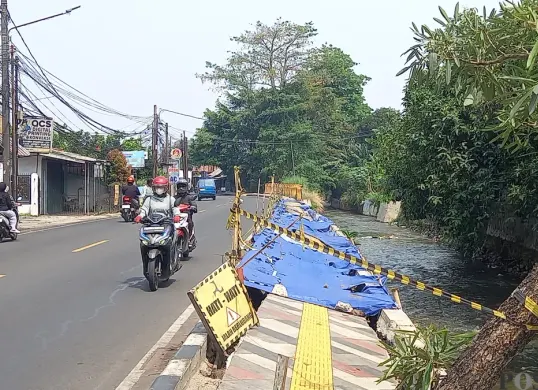 Kondisi trotoar di Jalan Raya Sawangan, Kecamatan Pancoran Mas, Kota Depok, Jawa Barat, ambles ke tepi saluran air, Senin, 28 September 2026. (Sumber: Poskota/Sabda Maulana)