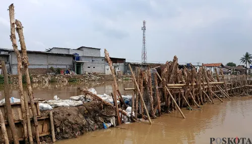 Kondisi Tanggul Kali Srengseng di Desa Sukamanah, Kecamatan Sukatani, Kabupaten Bekasi, tampak lebih surut debit airnya usai jebol pada Sabtu, 1 November 2025. (Sumber: POSKOTA | Foto: Nurpini Aulia Rapika)