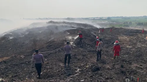 Petugas gabungan saat memadamkan api di TPA Jatiwaringin. (Sumber: Poskota/Veronica)
